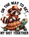 On Way To Get Shit Together Decal & Acrylic Blank Combo crafting supplies for making decorative badge reels and keychains.  UV DTF decal and coordinating clear acrylic blank for the glitter resin crafters. Raccoon in western wear riding a turtle with "On the way to get my shit together" text.  Funny sayings, idioms, novelty, humorous